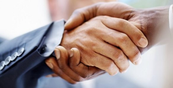 Closeup of business people shaking hands over a deal